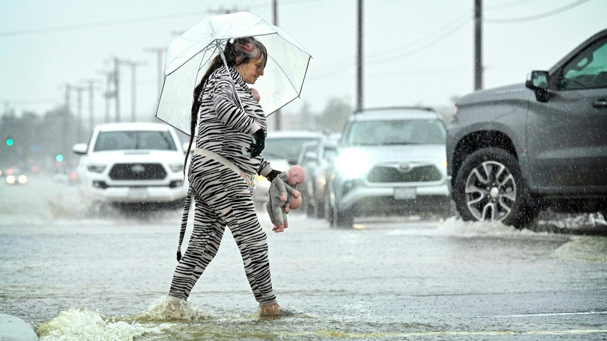 Eine Frau in einem Zebra-Kostüm überquert die Straße bei Regen.
