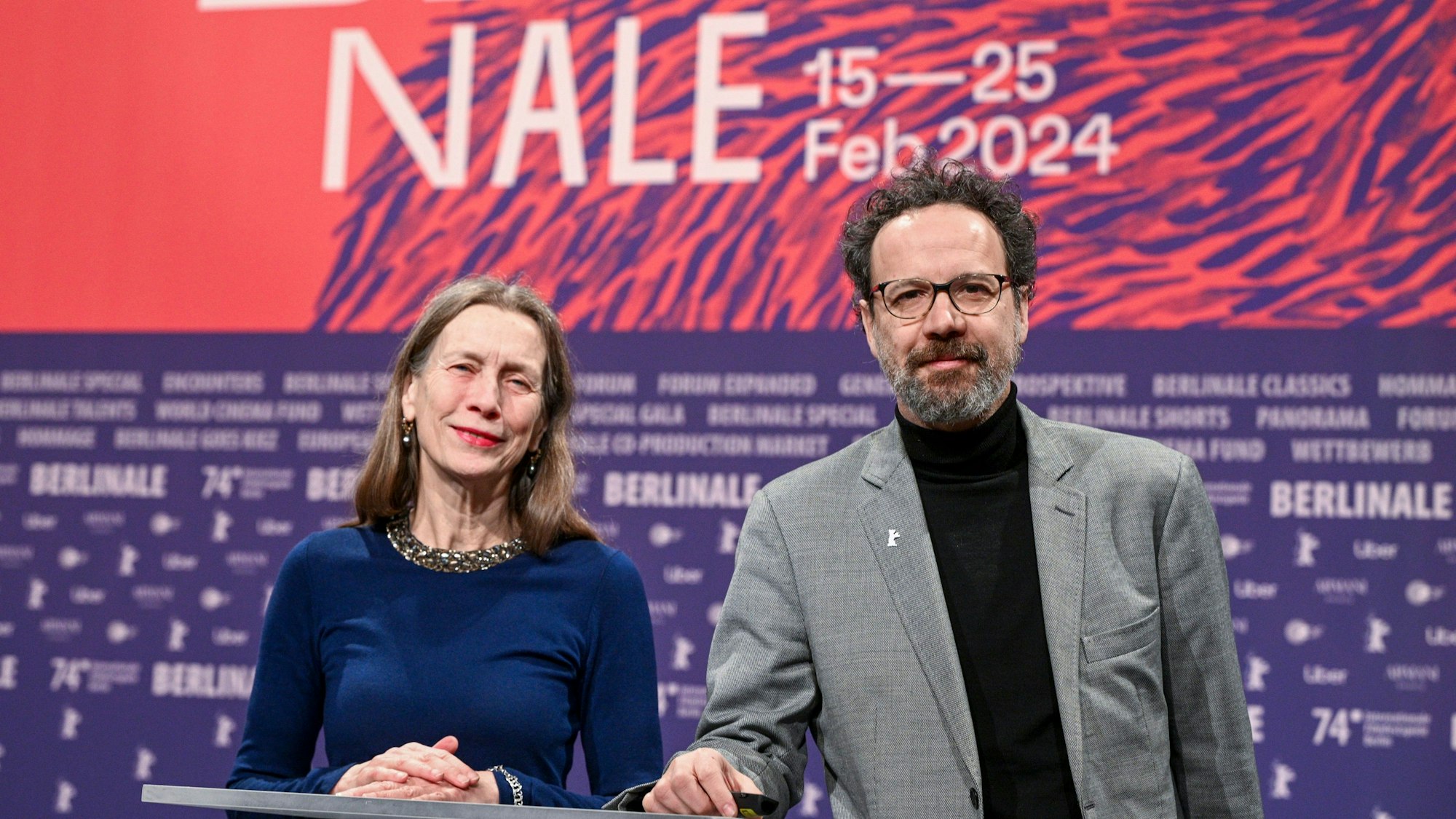 Das Leitungs-Duo der Berlinale, Mariette Rissenbeek, Geschäftsführerin, und Carlo Chatrian, künstlerischer Direktor, stehen vor Beginn der Pressekonferenz zur Vorstellung Bekanntgabe des Berlinale-Programms 2024 mit Merchandiseartikeln der Berlinale auf der Bühne.