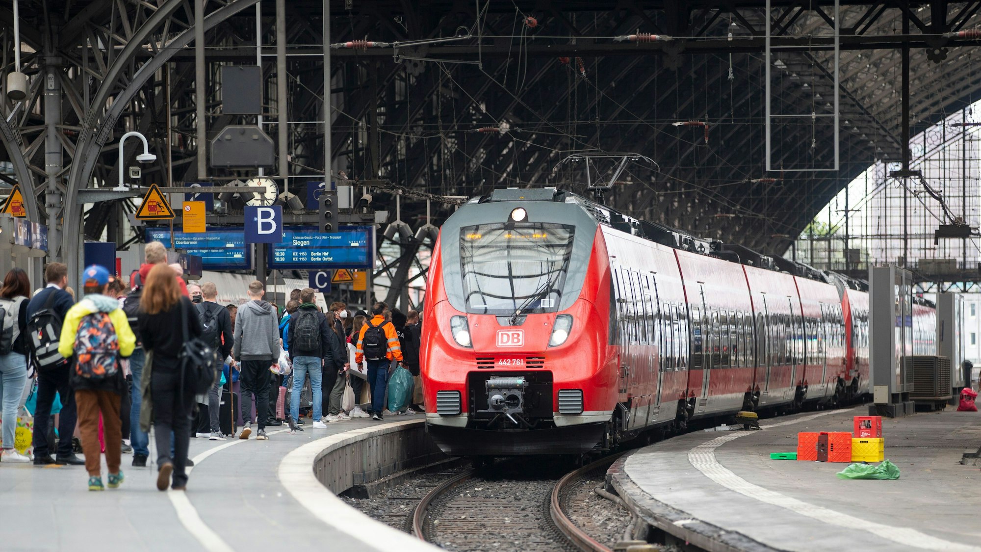 Bahnreisende warten auf dem Bahnsteig auf die Einfahrt des Zuges im Kölner Hauptbahnhof.