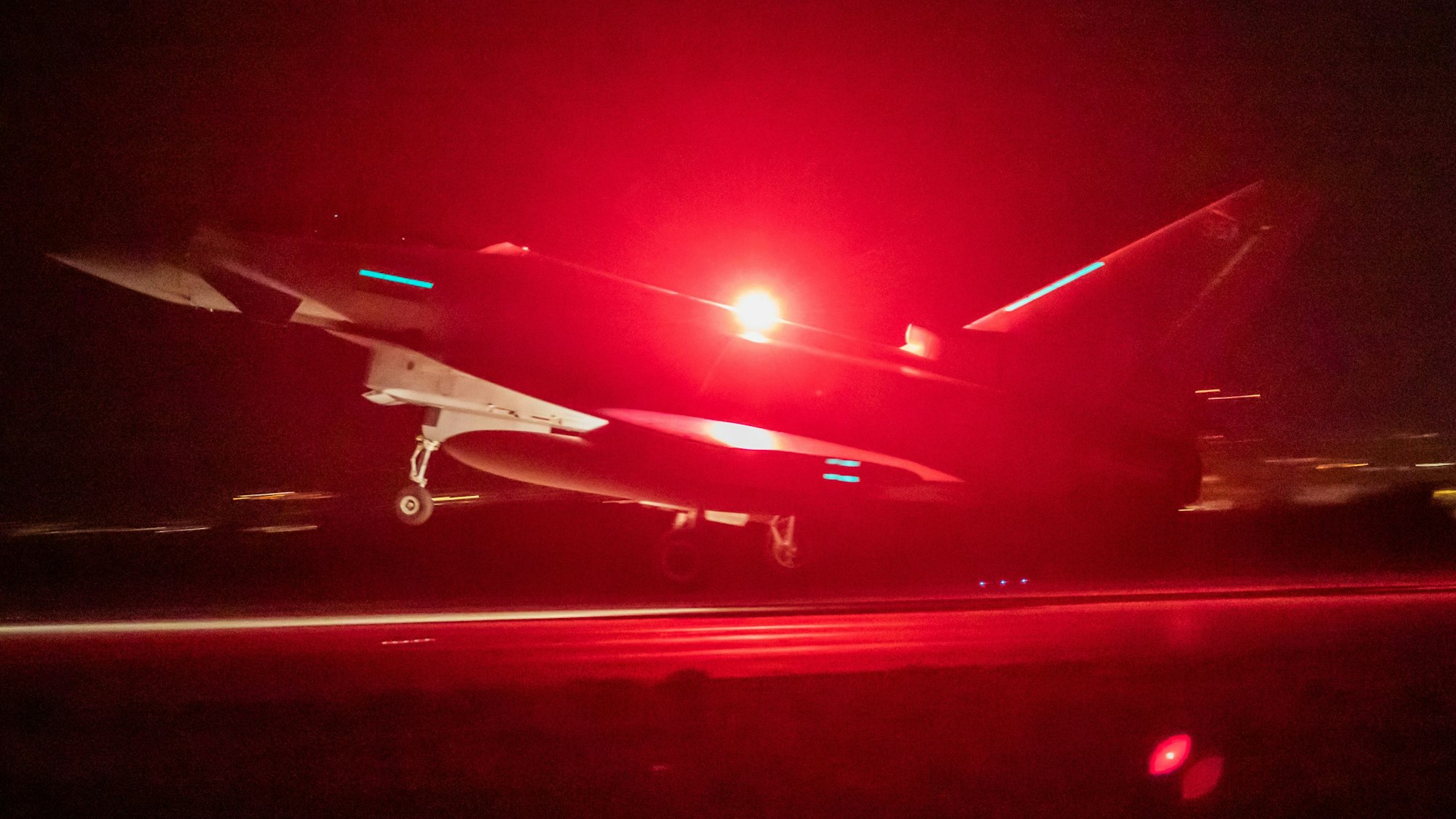 Ein Eurofighter Typhoon der British Royal Air Force beim Start auf einem Luftwaffen-Stützpunkt. Dabei ist ein rotes Warnlicht angeschaltet. (Archivbild)