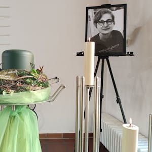 Die Urne mit der Asche von Elke Bahn, daneben eine Kerze und ein Bild der Buchhändlerin.