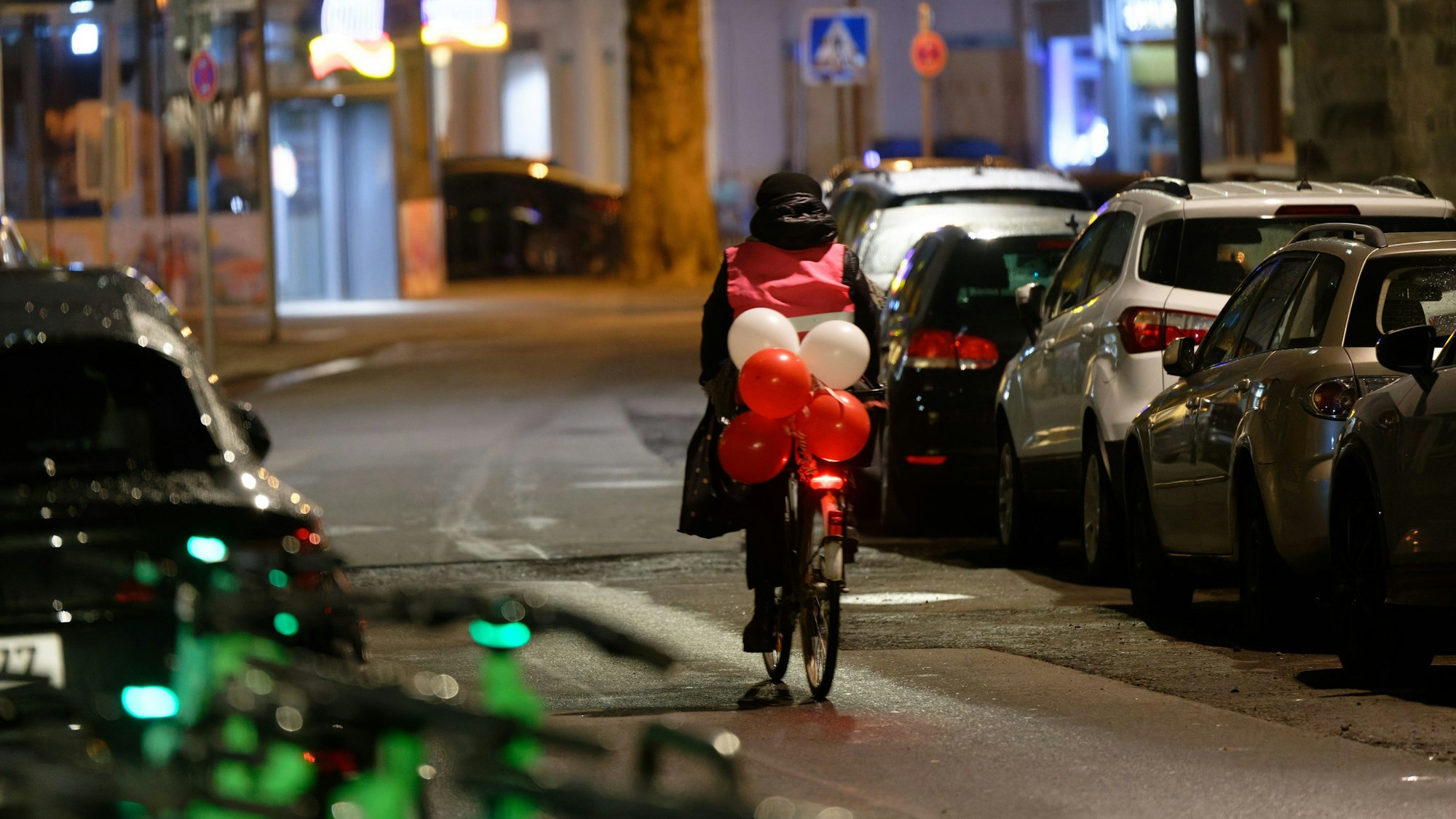 Ein mit rot-weißen Luftballons geschmücktes Fahrrad fährt am frühen Morgen an Weiberfastnacht durch die Innenstadt.
