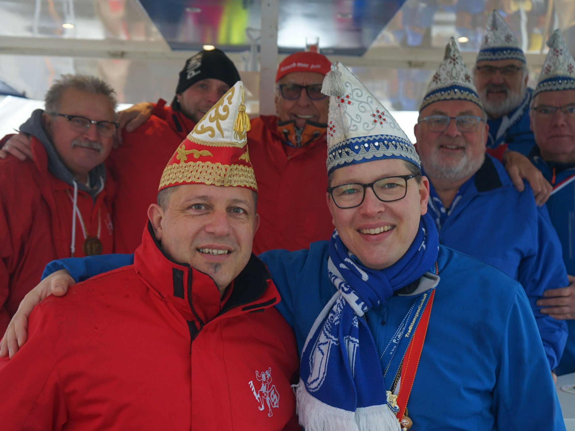Vertreter der Karnevalsgesellschaften in roten und blauen Jacken.
