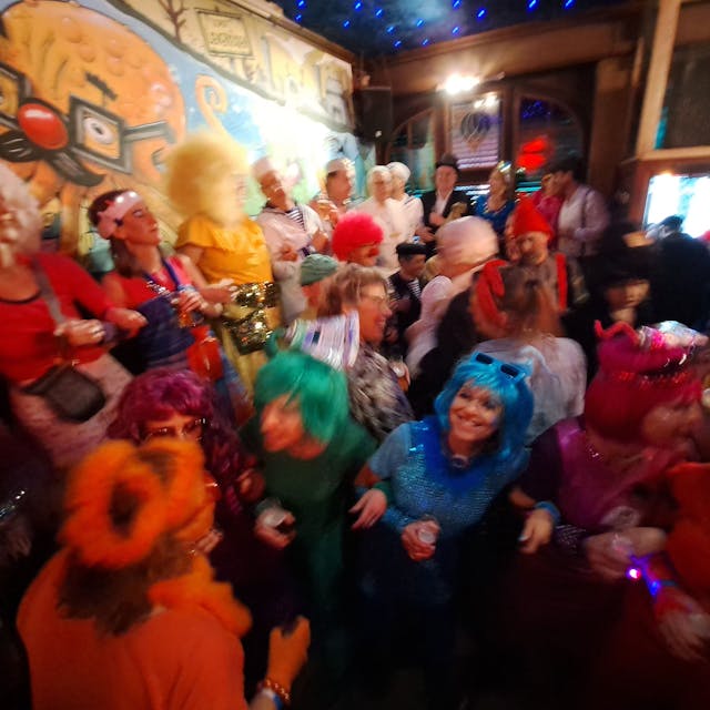 Kostümierte Menschen feiern in einer Kneipe.