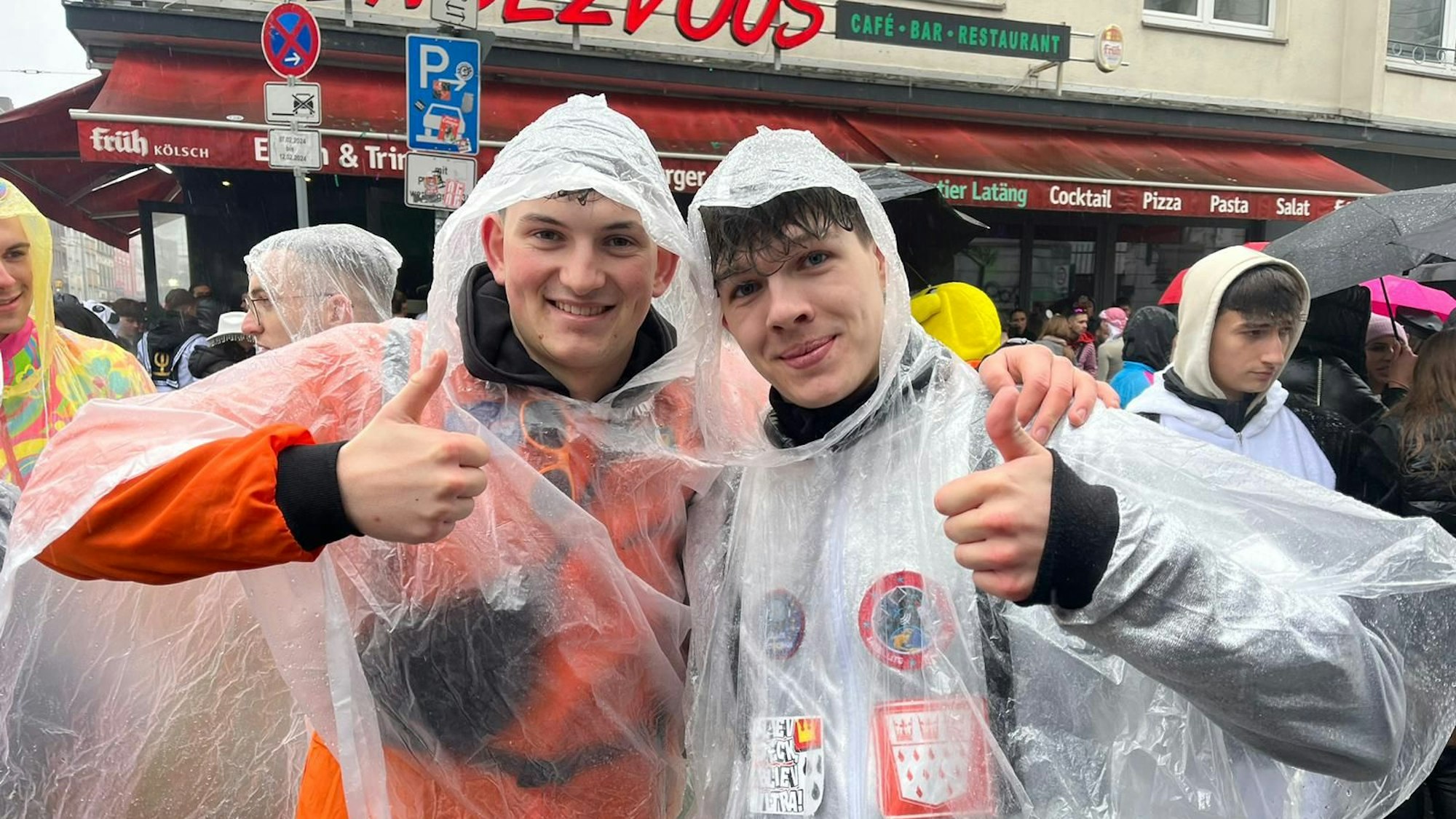 Zwei junge Männer in Regenanzügen im Karneval.