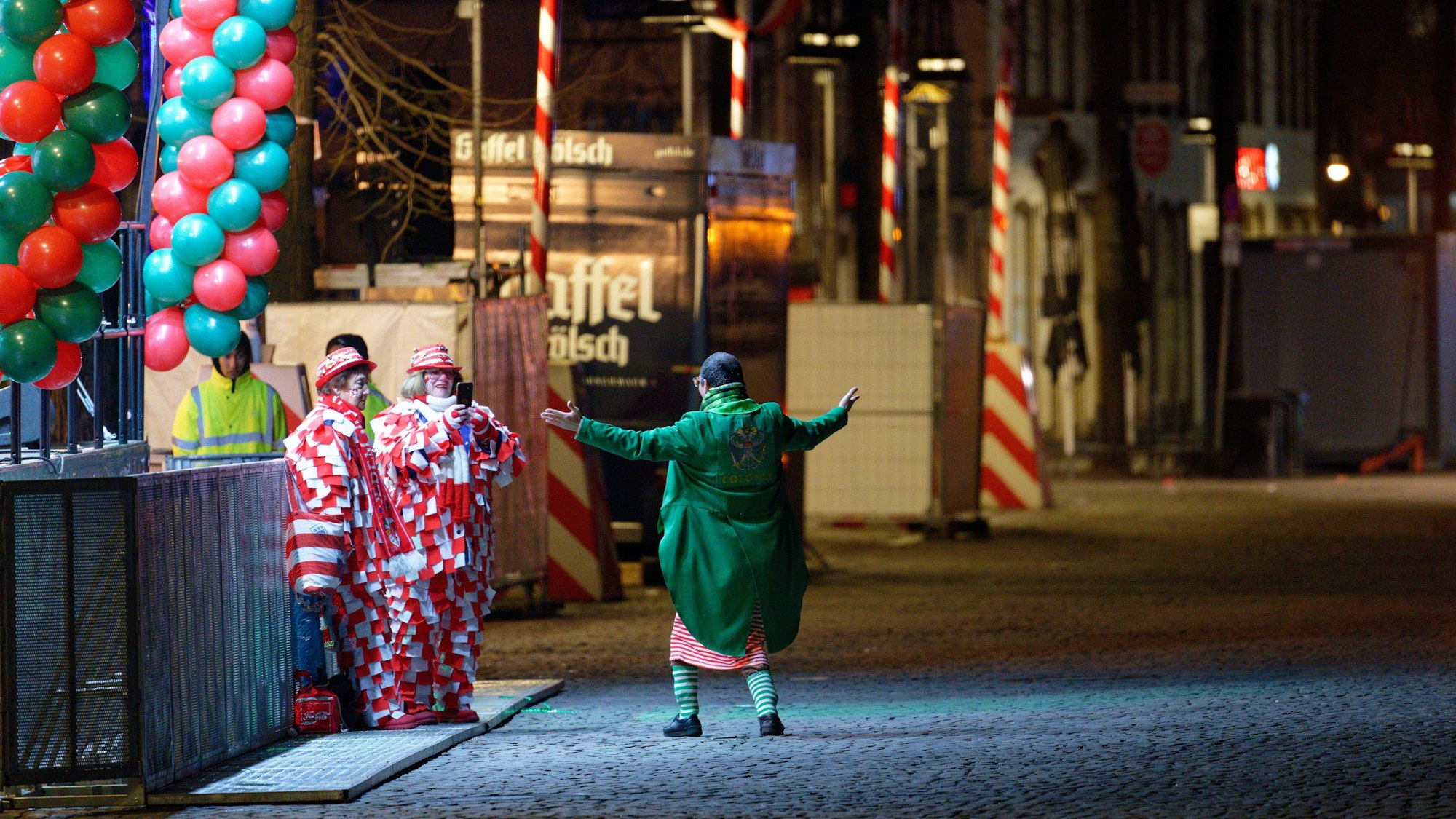 Karnevalisten stehen am frühen Morgen an Weiberfastnacht vor der Bühne am Alter Markt, um die Ersten zu sein.