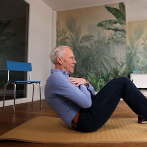 Ingo Froböse zeigt auf der Fitnessmatte eine Übung für die Bauchmuskulatur.&nbsp;