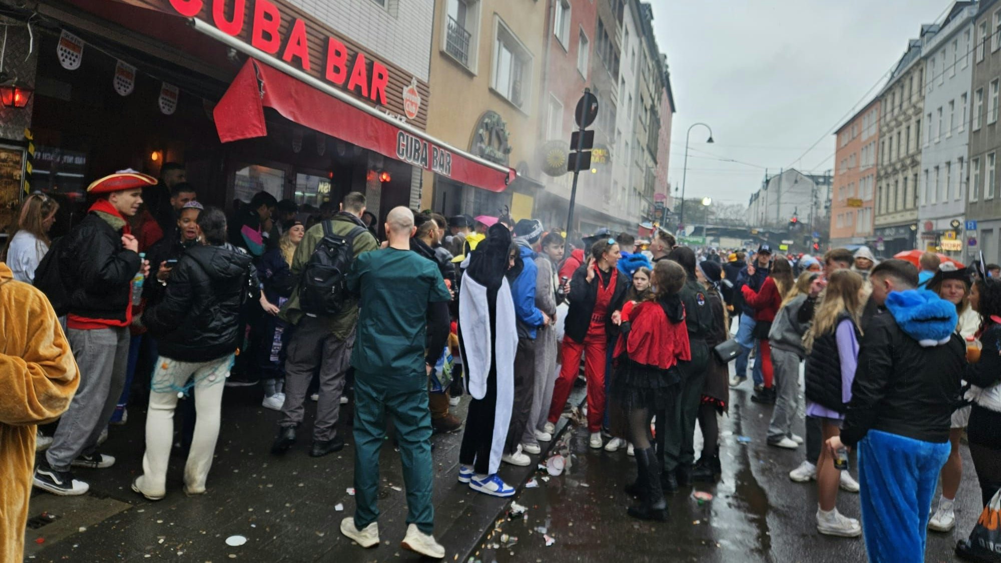 Menschen feiern vor einer Bar auf der Zülpicher Straße.