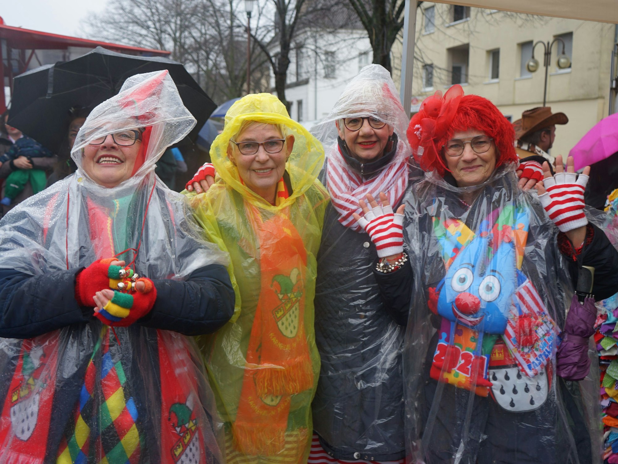 Vier Frauen auf dem Stiftsplatz. Ihre Kostüme schützen sie mit Regenponchos.