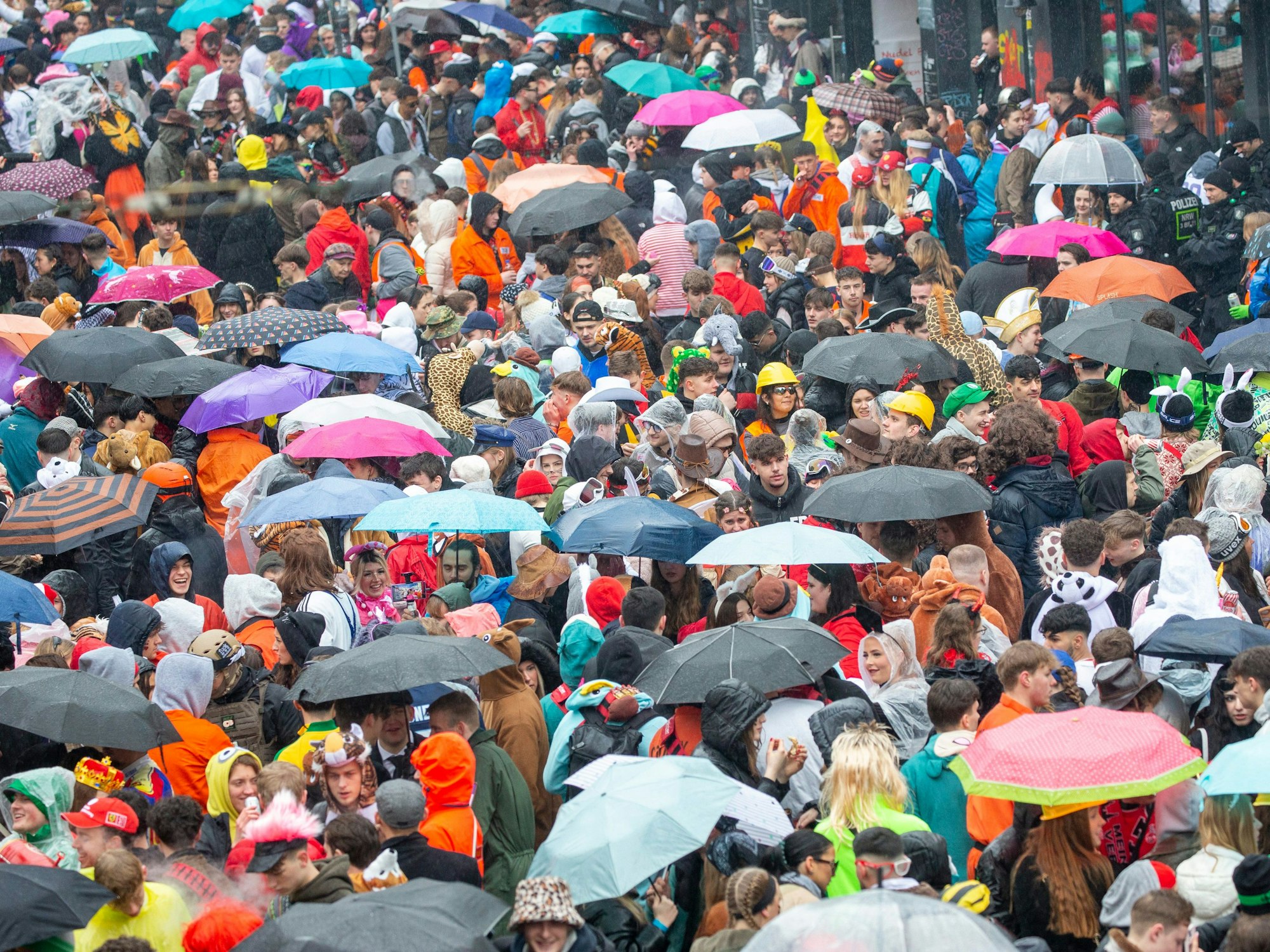 Junge Karnevalisten feiern trotz Regen auf der Zülpicher Straße.