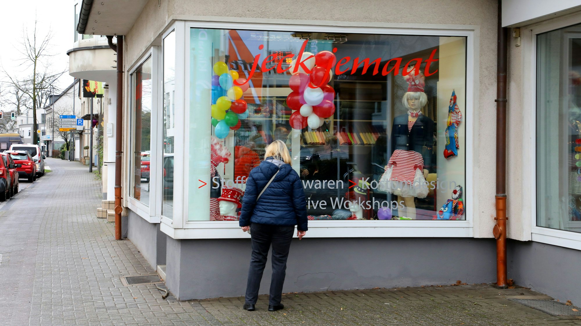 Eine Frau steht vor Heike Funks „Jeck jemaat“-Laden in Bergisch Gladbach-Heidkampo und schaut ins Schaufenster.