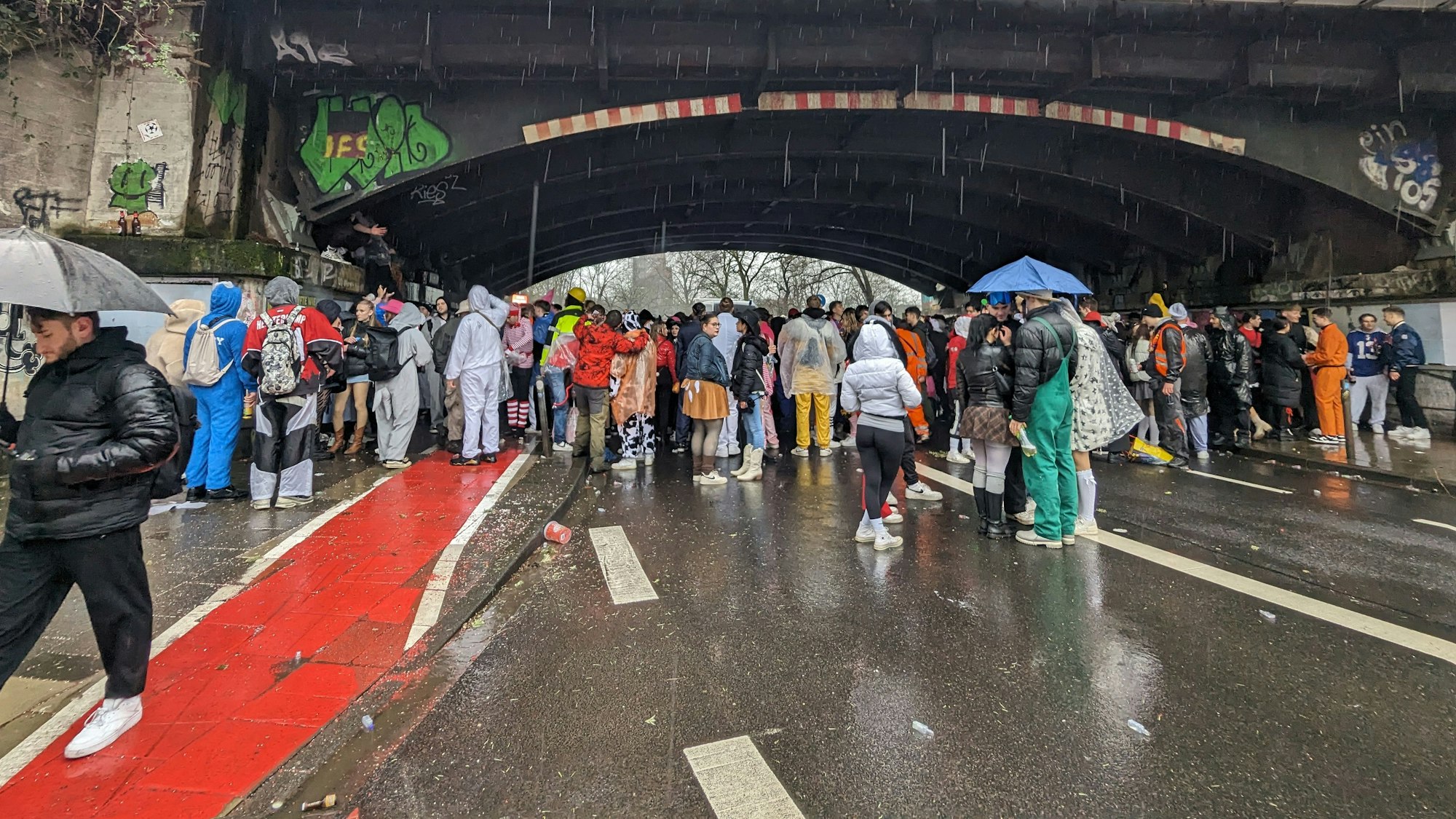 Eine Miniparty findet unter der Brücke an der Ecke Lindenstraße/Zülpicher Wall statt. Da ist es trocken, die Feiernden knubbeln sich auf dem kleinen Stück.