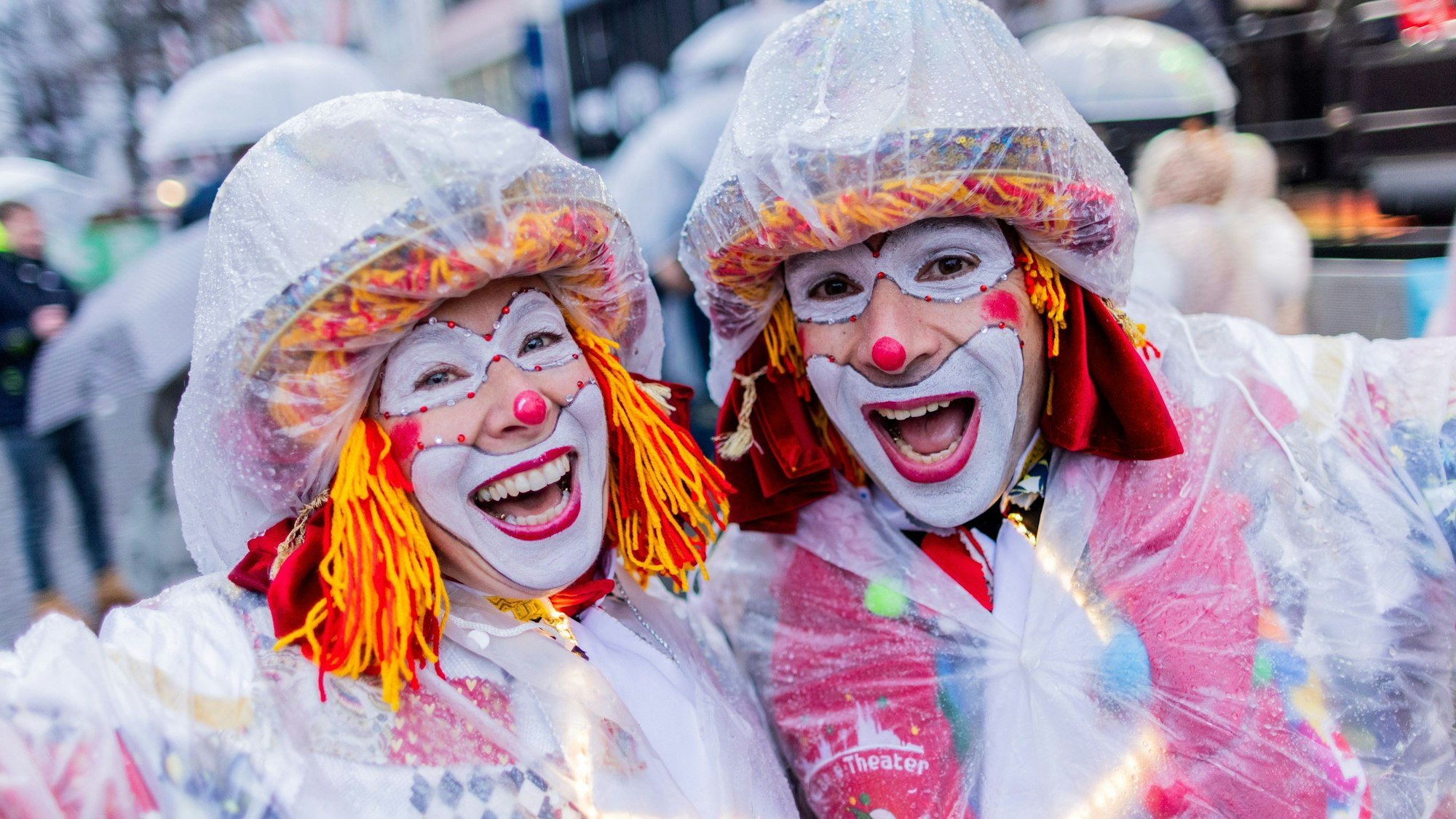 Wer ein richtiger Karnevalist ist, der hat sich wetterfest vorbereitet. Diese Clowns haben sich von Kopf bis Fuß in Plastikfolie gehüllt und trotzen dem strömenden Regen.