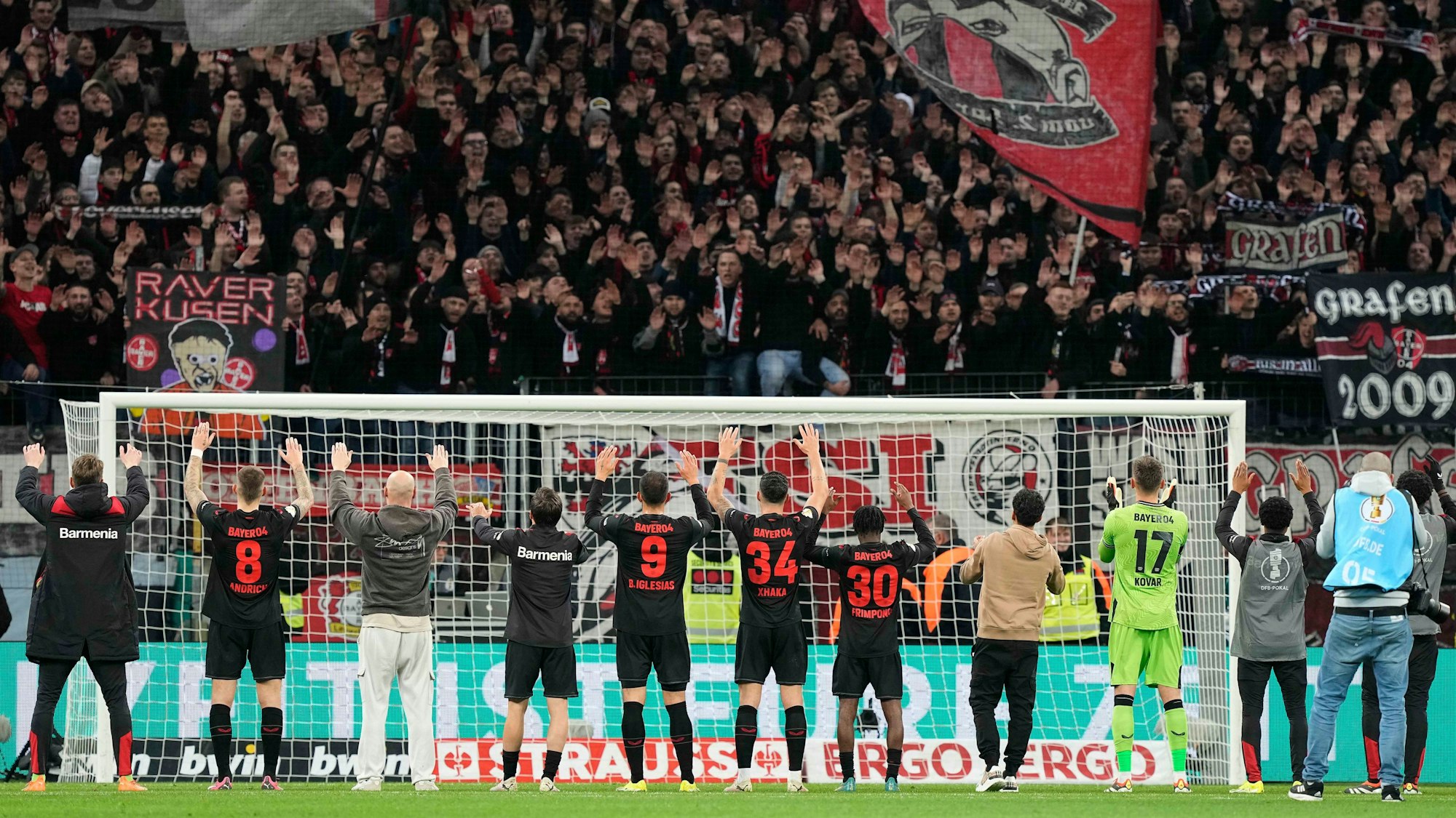 Die Profis von Bayer Leverkusen jubeln mit den Fans.
