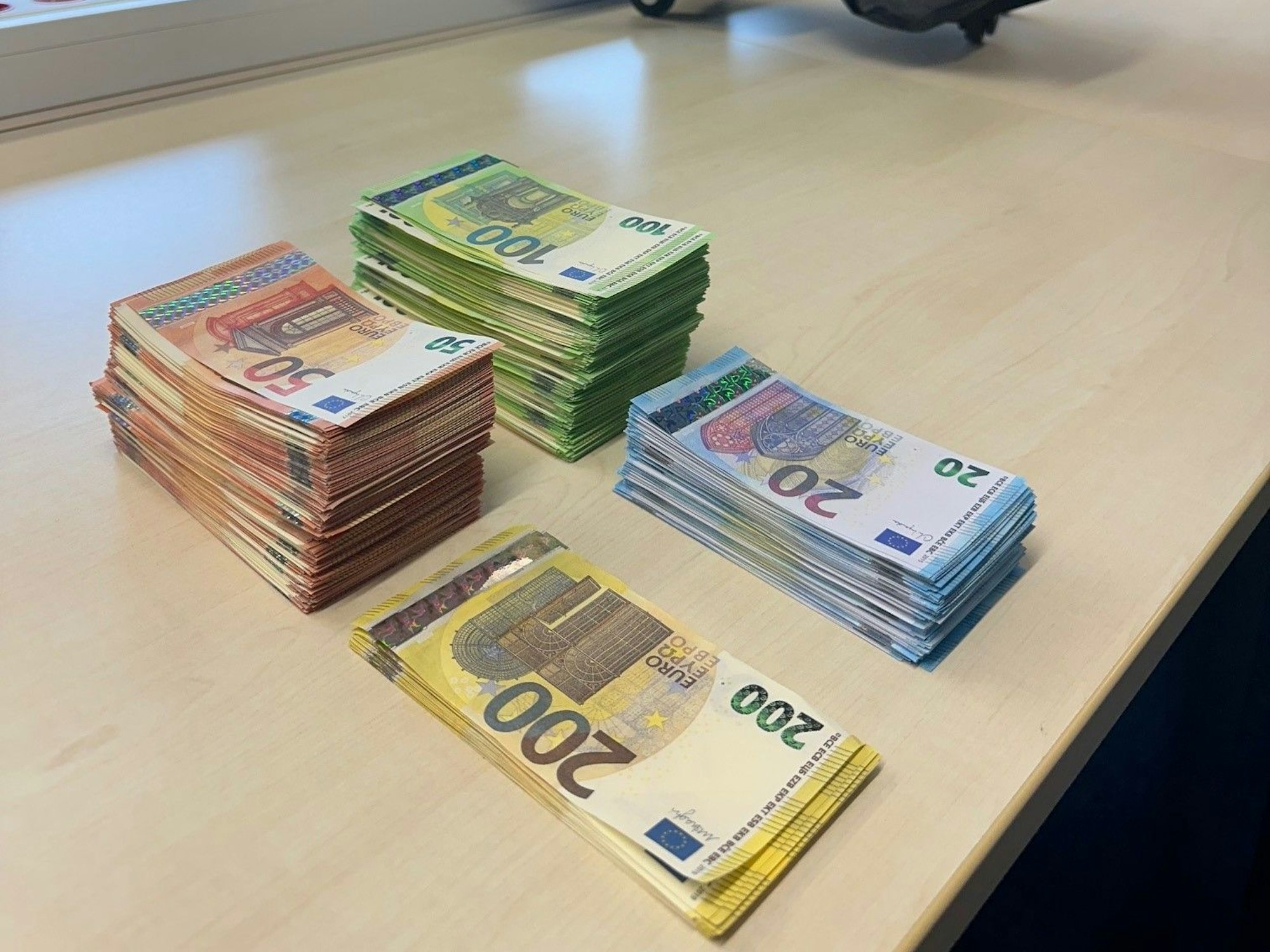 Falsche 200-, 100-, 50- und 20-Euro-Scheine liegen jeweils gestapelt auf einem Tisch.