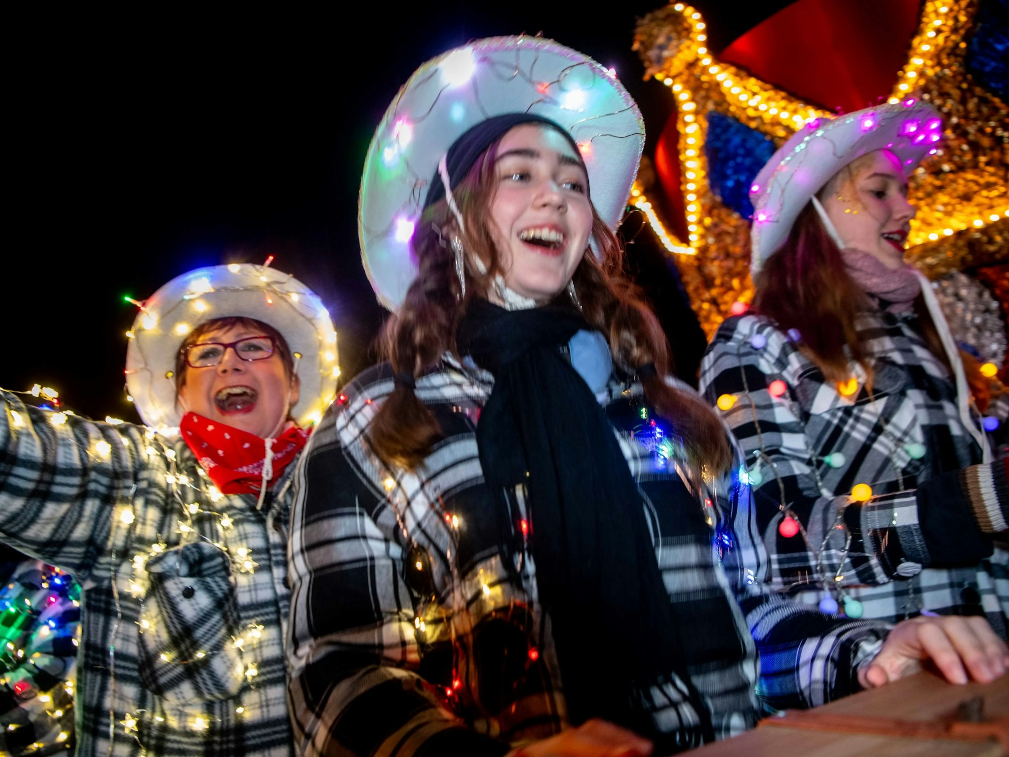 Drei verkleidete Frauen feiern den Lichterzug.