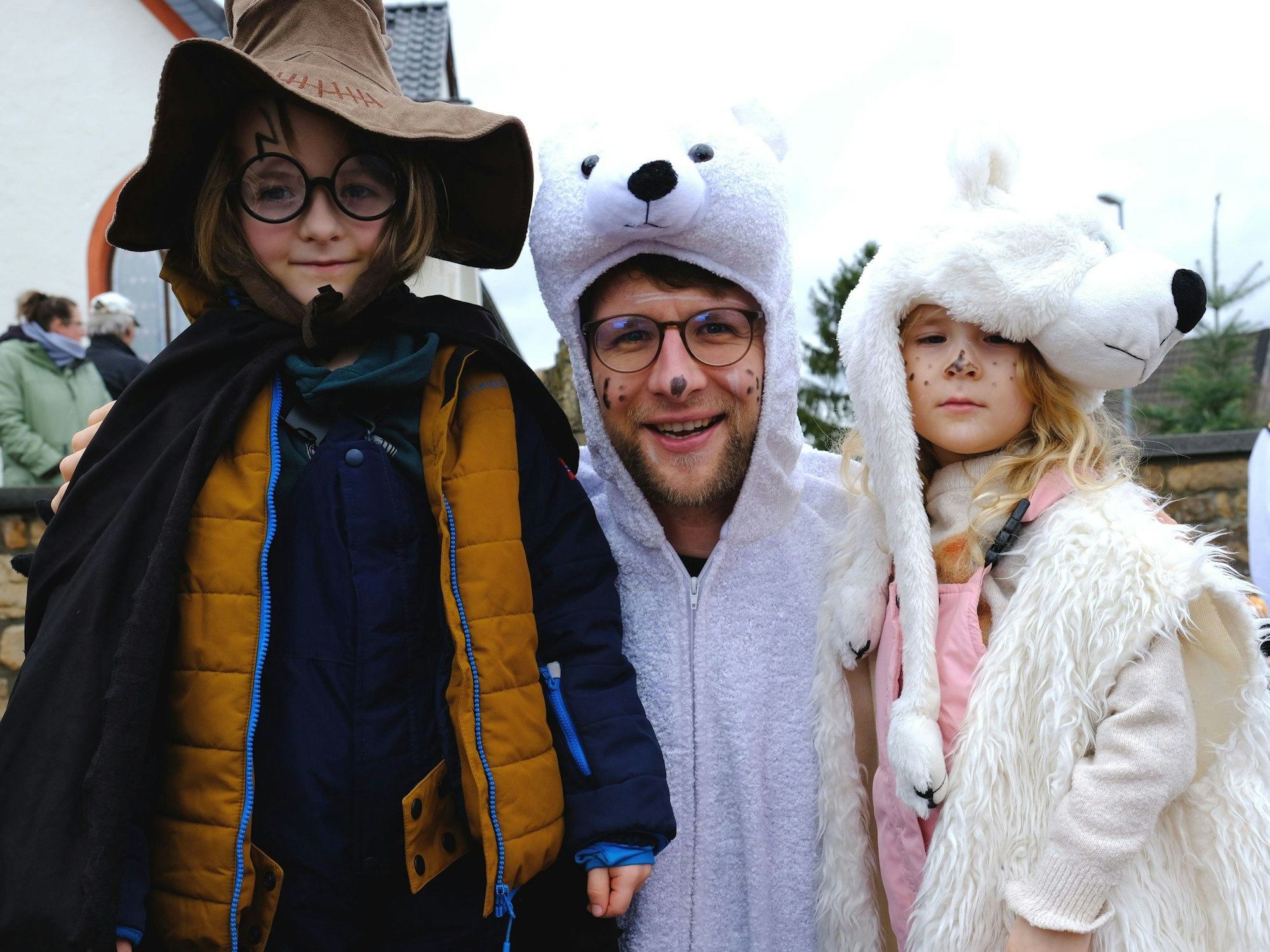 Als Harry Potter und Eisbären verkleidete Karnevalisten schauen sich den Bergheimer Kinderzugs an.