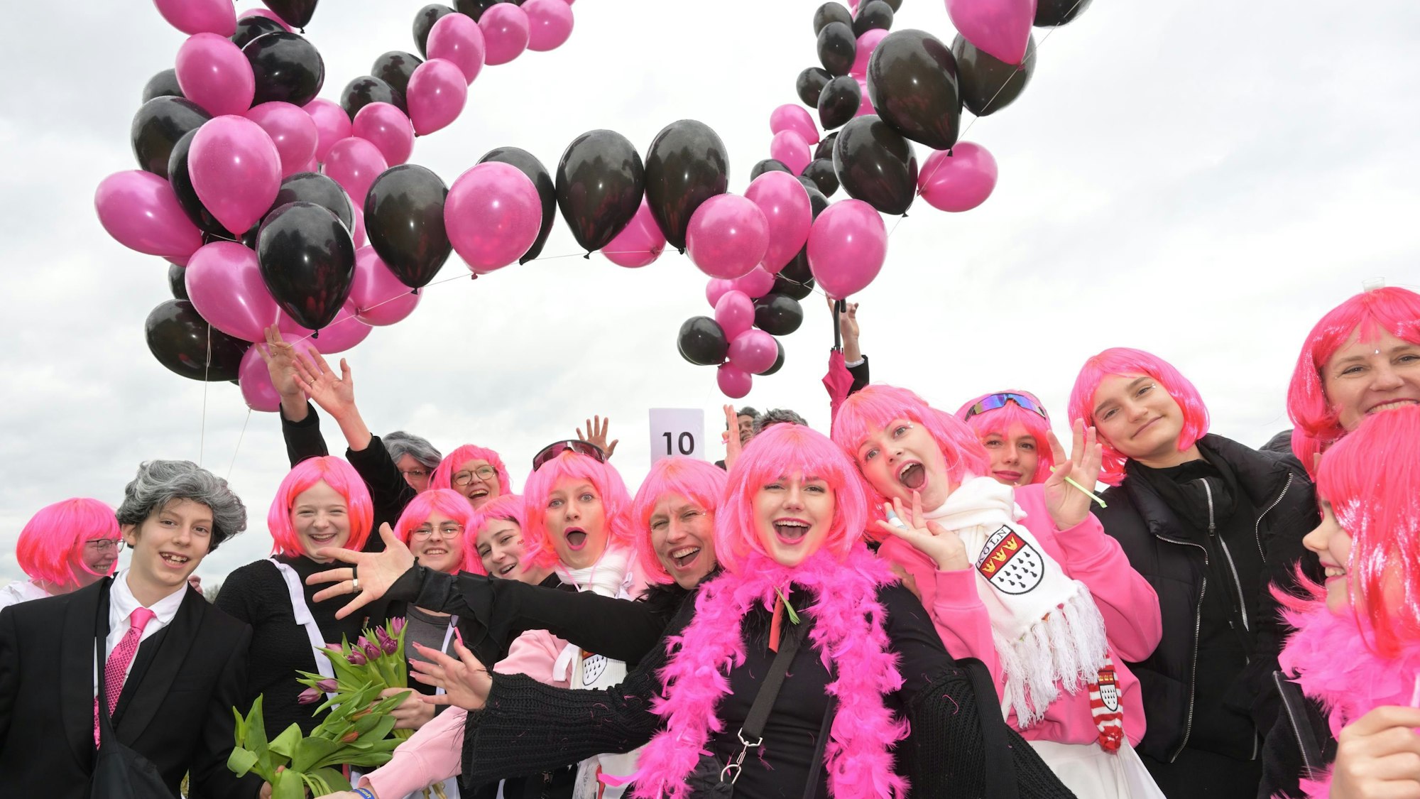 Kostümierte Jugendliche mit rosa Perücken und Luftballon