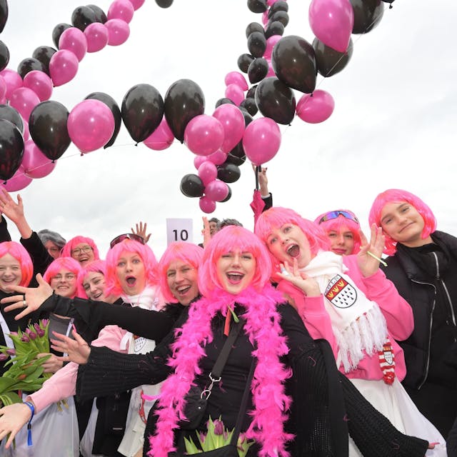 Kostümierte Jugendliche mit rosa Perücken und Luftballon