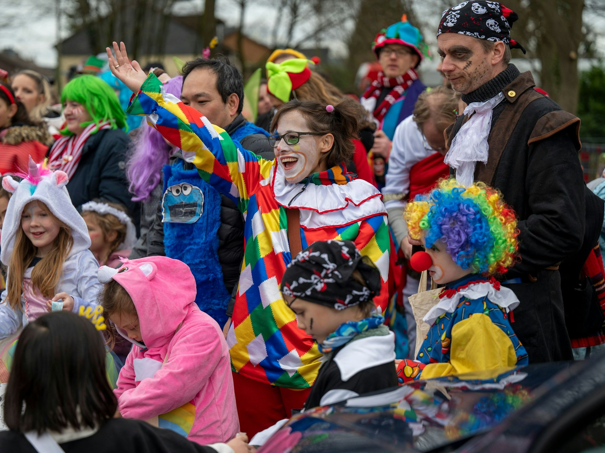 Die gute Laune war den Teilnehmenden beim Karnevalszug im Merheimer Veedel am 10. Februar anzusehen. Eine als Clown verkleidete Frau ruft etwas in die Menge.