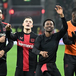Leverkusens Borja Iglesias, Florian Wirtz und Nathan Tella (l-r) feiern nach dem Spiel.