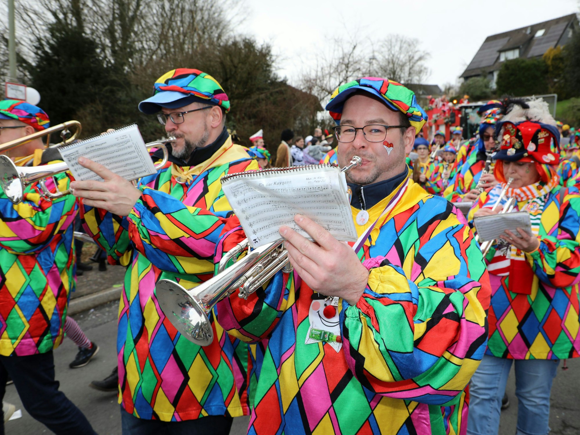 Bunt kostümierte Musiker gehen in einem Karnevalszug mit.