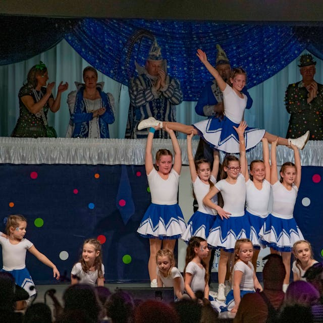 Eine Karnevals-Kindertanzgruppe zeigt eine Choreografie auf der Bühne einer Sitzung.