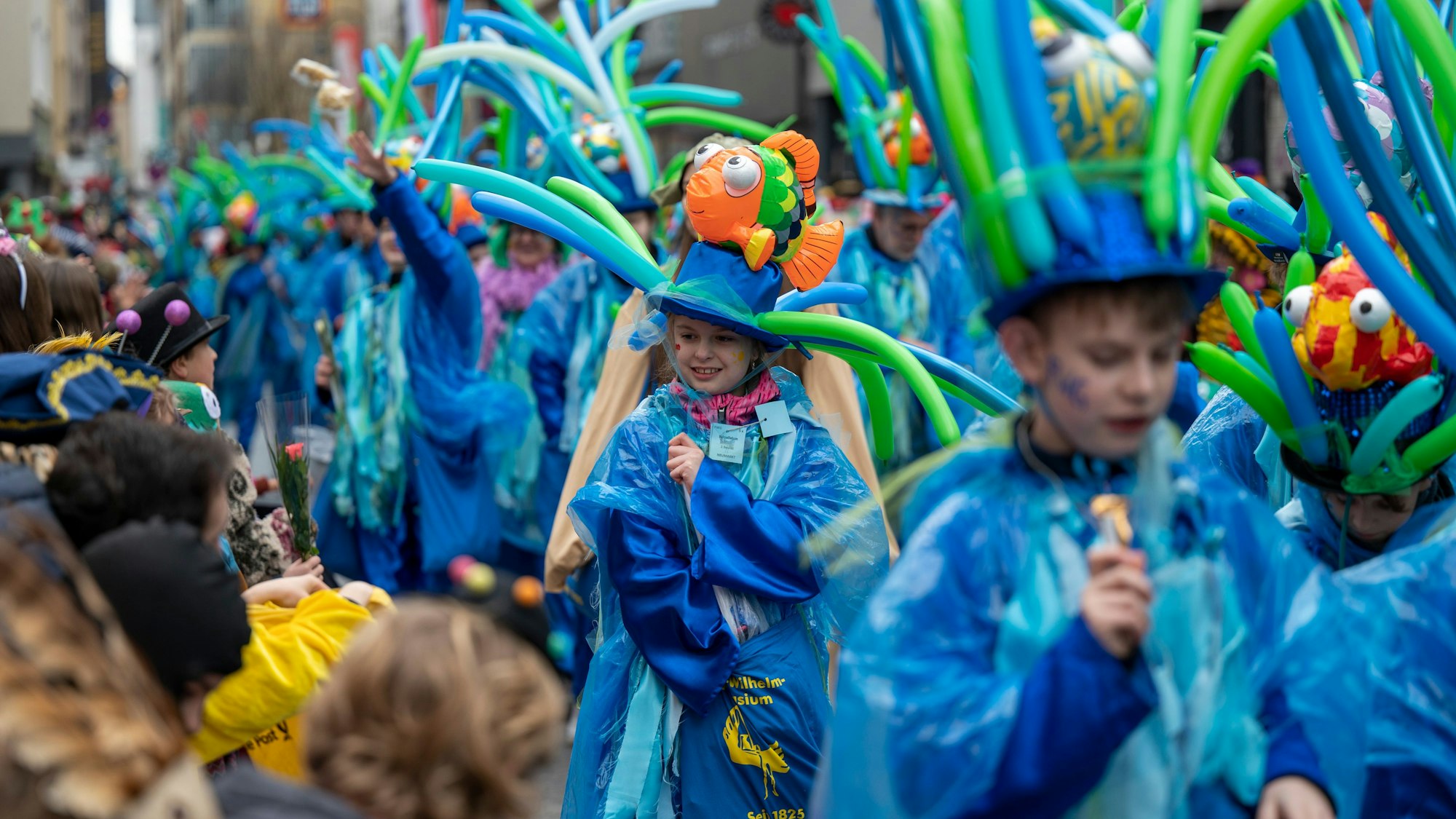 Die Welt als blauen Planeten stellt das Kostüm des Friedrich-Wilhelm-Gymnasiums dar. Hier thront ein Clownfisch auf der Kopfbedeckung einer Schülerin.