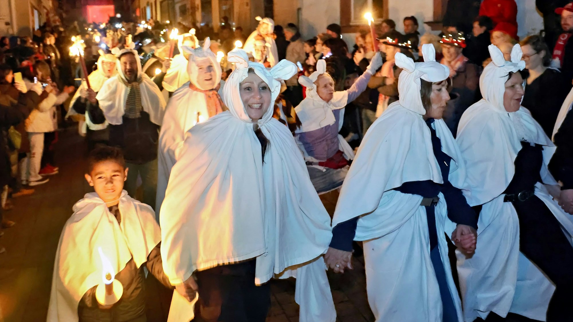 Der Zug der Geister zieht kreischend durch die Straßen von Blankenheim. In dem Traditionszug sind die Teilnehmer mit weißen Bettlaken verkleidet. Viele haben Pechfackeln in der Hand.