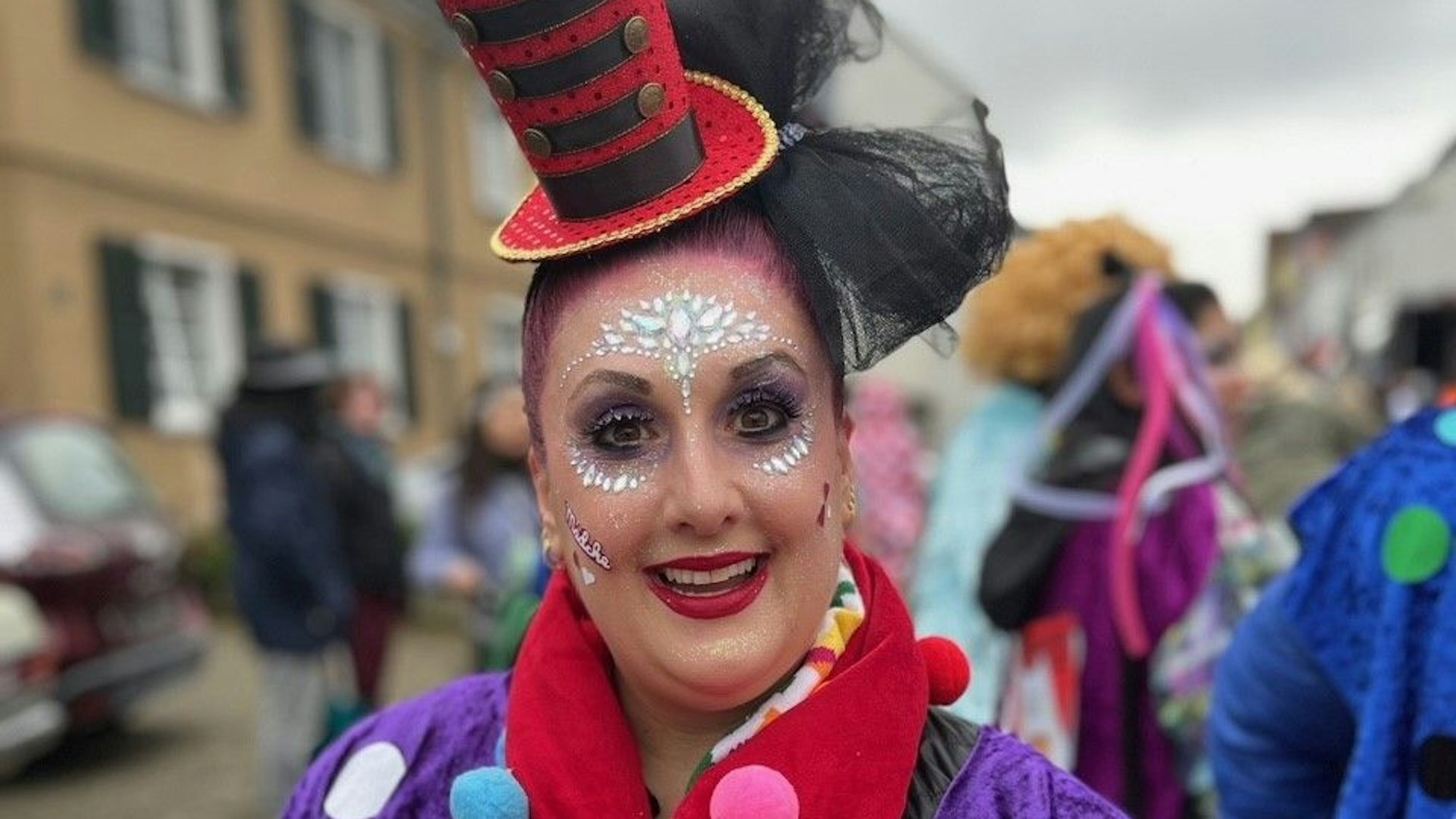 Frau trägt buntes Kostüm mit aufwendigem Make-up