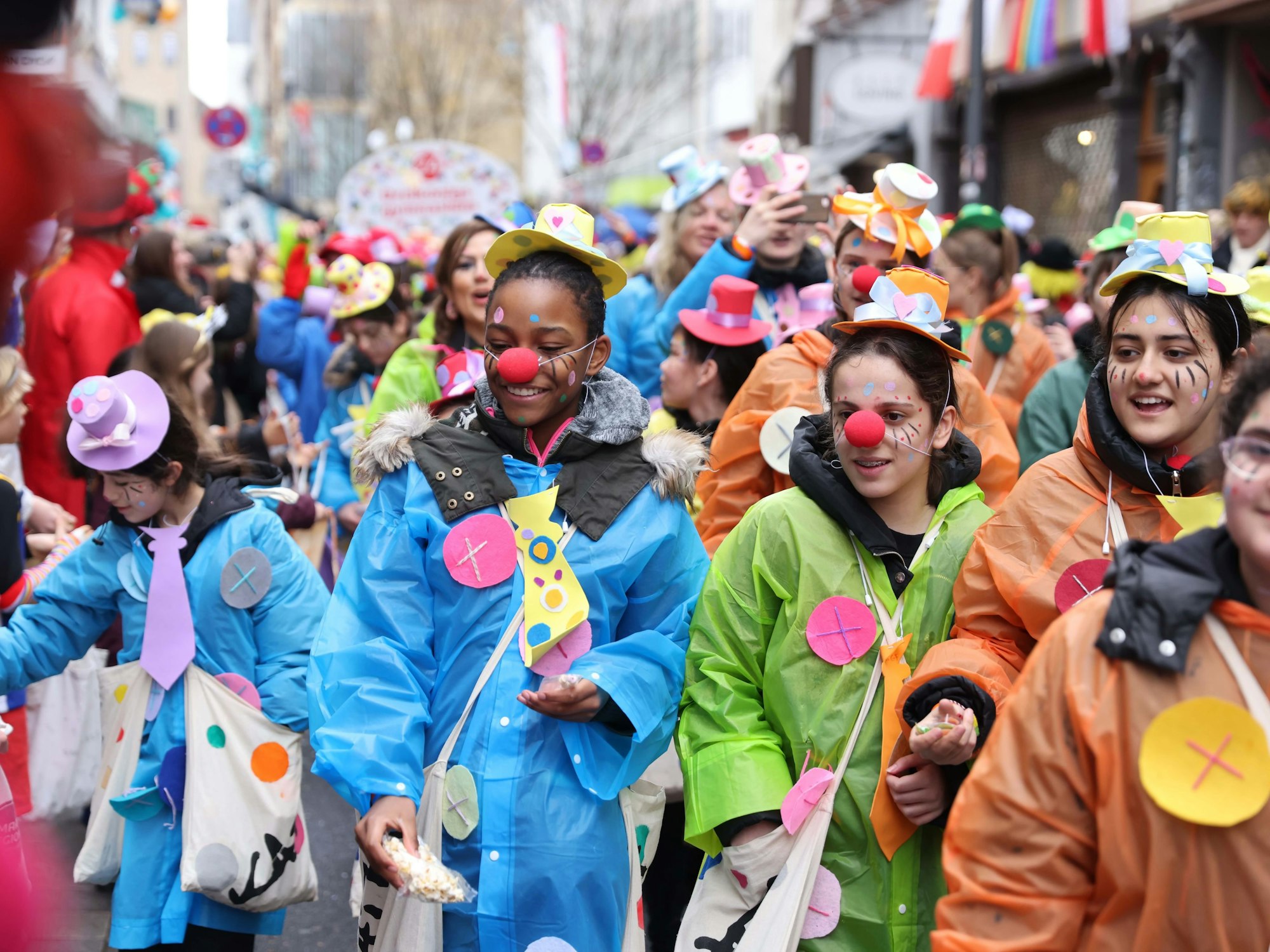 Schülerinnen und Schüler in regenfesten Karnevalskostümen.