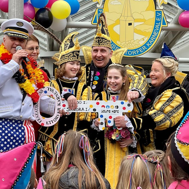 Ein Kinderprinzenpaar und ein erwachsenes Paar in prunkvollen schwarz-gelben Kostümen stehen lachend auf der Treppe zum Rathaus und halten einen großen Schlüssel in der Hand, die ihnen ein als Kapitän verkleideter Bürgermeister Rainer Viehof übergibt.