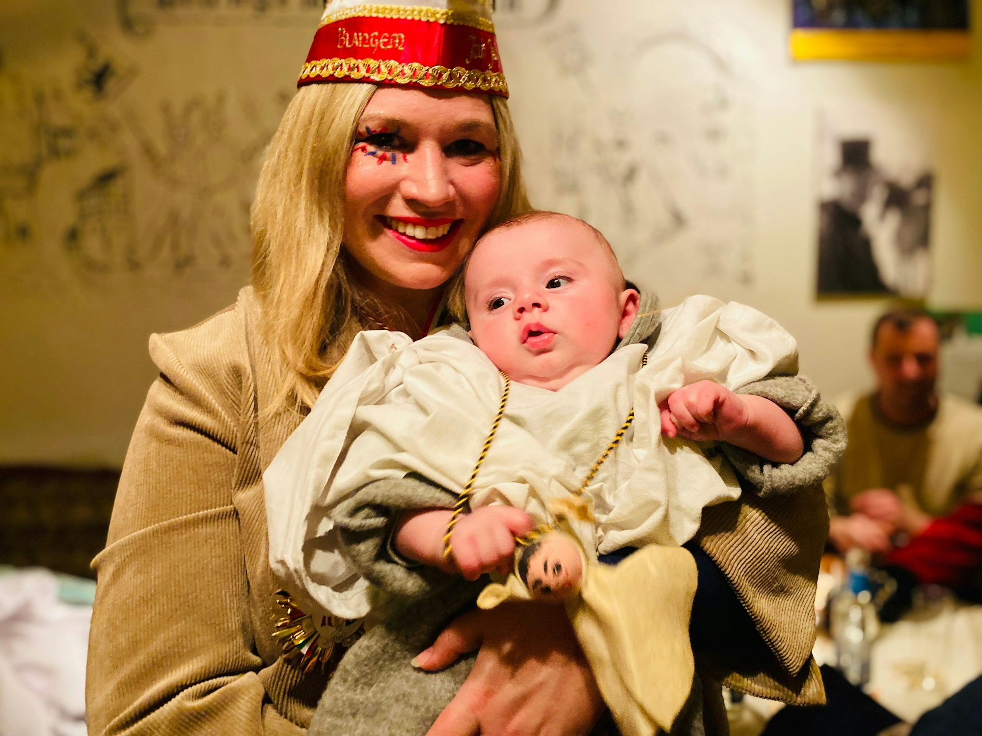Die Blankenheimer Bürgermeisterin Jennifer Meuren hält ihren kleinen Sohn Levi auf dem Arm. Sie trägt eine Narrenkappe, der Junge ein kleines Geisterkostüm.