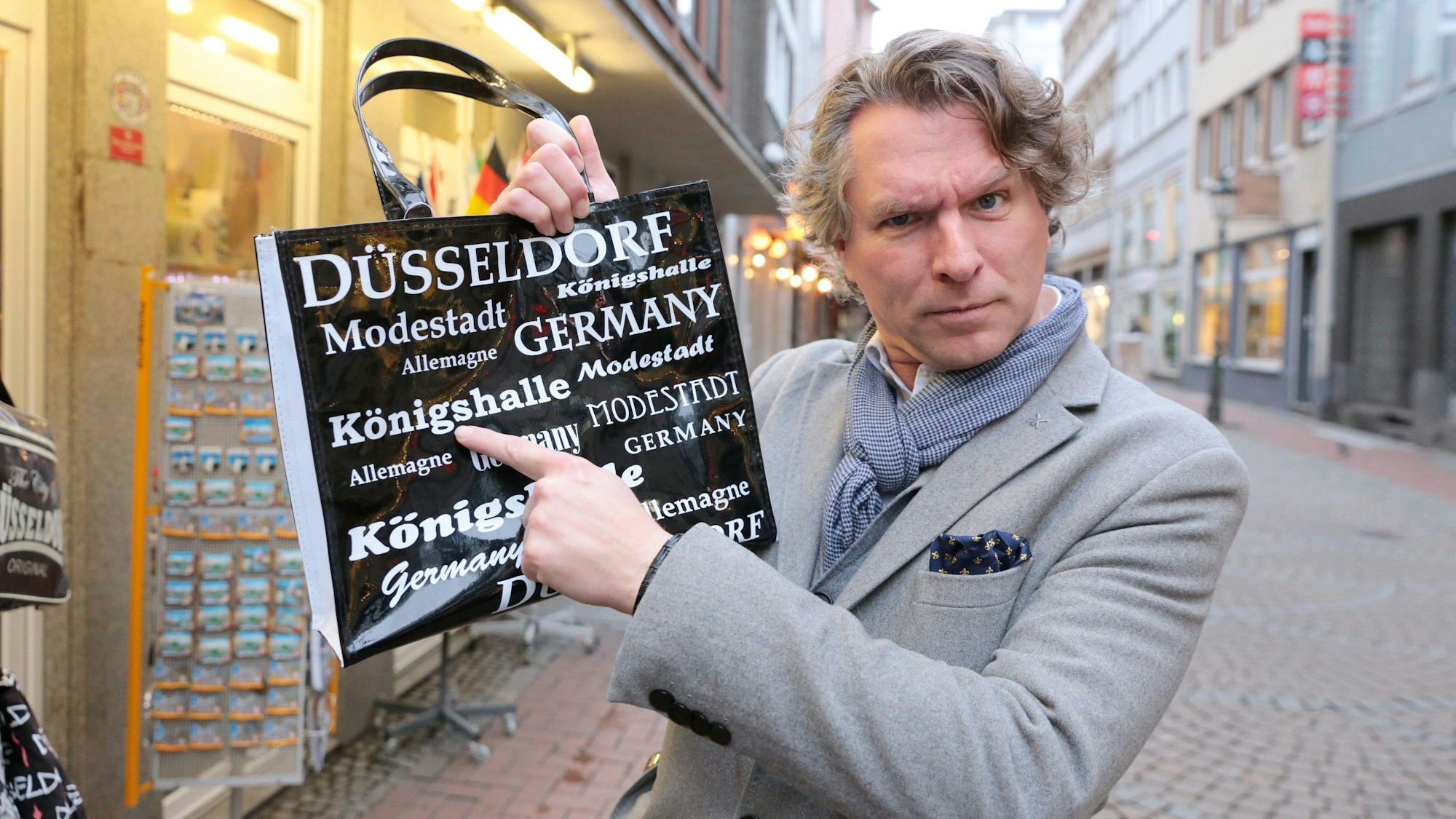Der Düsseldorfer Stadtführer Thorsten Happel hält am 7. Februar 2024 die Tasche mit dem Druckfehler.