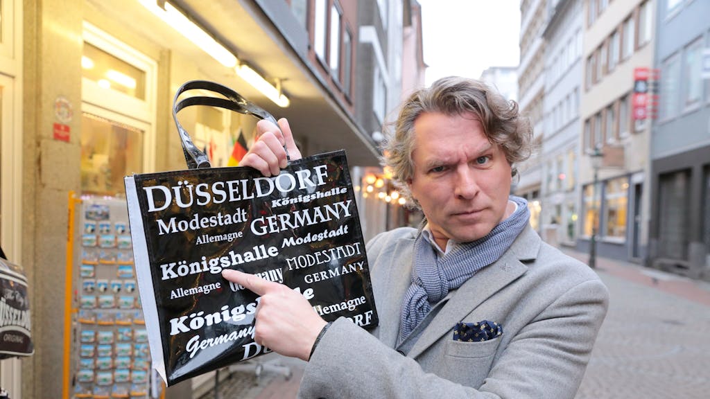 Der Düsseldorfer Stadtführer Thorsten Happel hält am 7. Februar 2024 die Tasche mit dem Druckfehler.