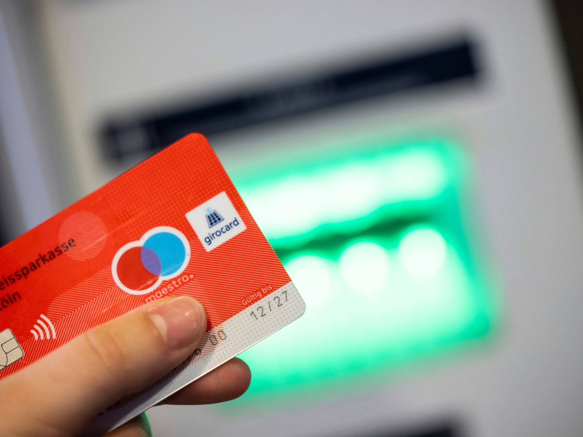 Eine Bankkundin verwendet ihre Girokarte, auf der das Girocard-Logo (r) und das rot-blaue Maestro-Logo (2-r) abgebildet sind, um Bargeld an einem Geldautomaten abzuheben, hier im Januar 2023 in Königswinter.