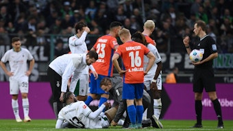 Jordan Siebatcheu wird auf dem Rasen im Borussia-Park behandelt.