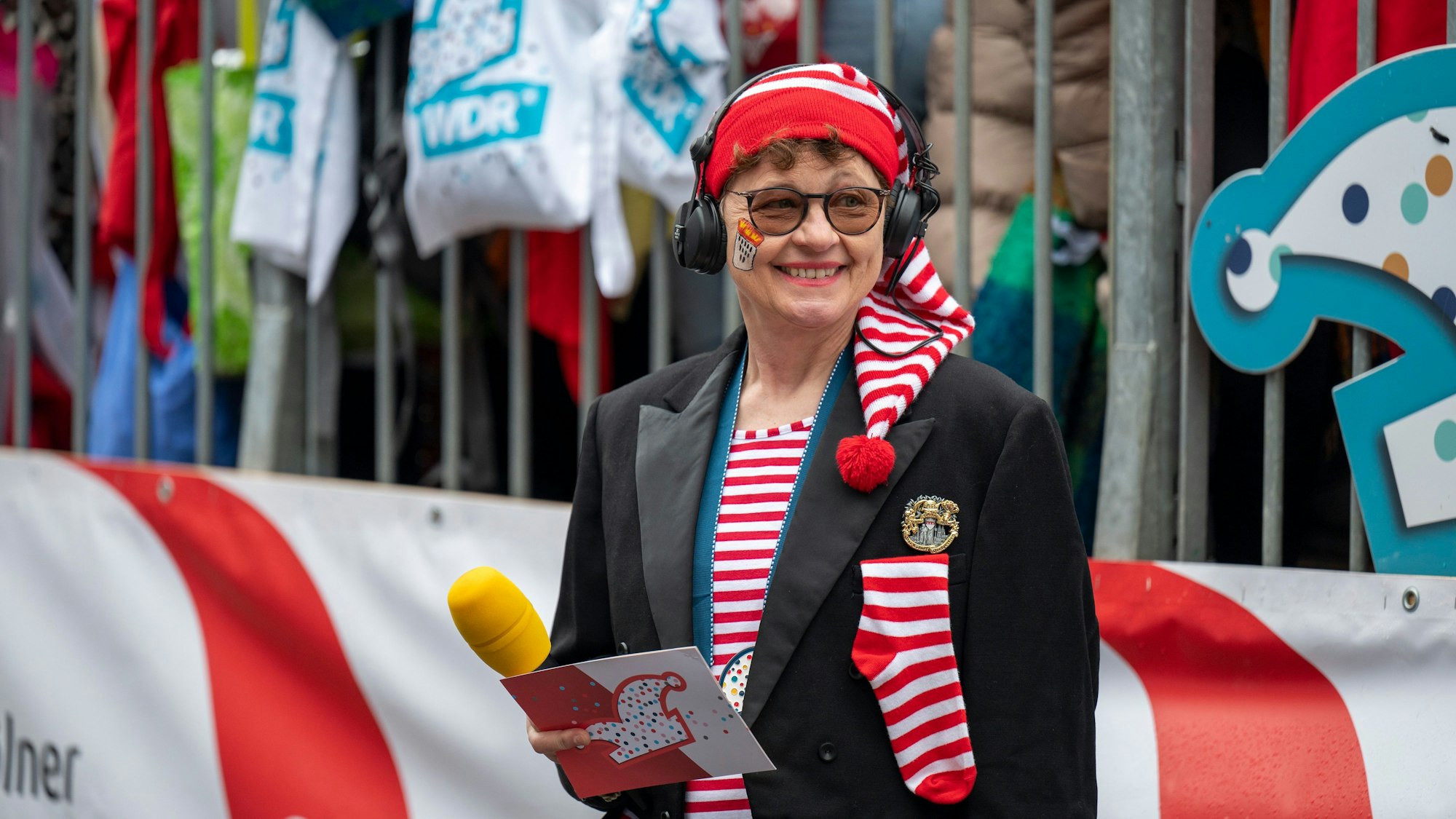 Der Karnevalszug wird auch im Fernsehen übertragen. Zum Moderatorinnenteam gehört hier auch die Journalistin Monika Salchert, die auch für den „Kölner Stadt-Anzeiger“ schreibt.