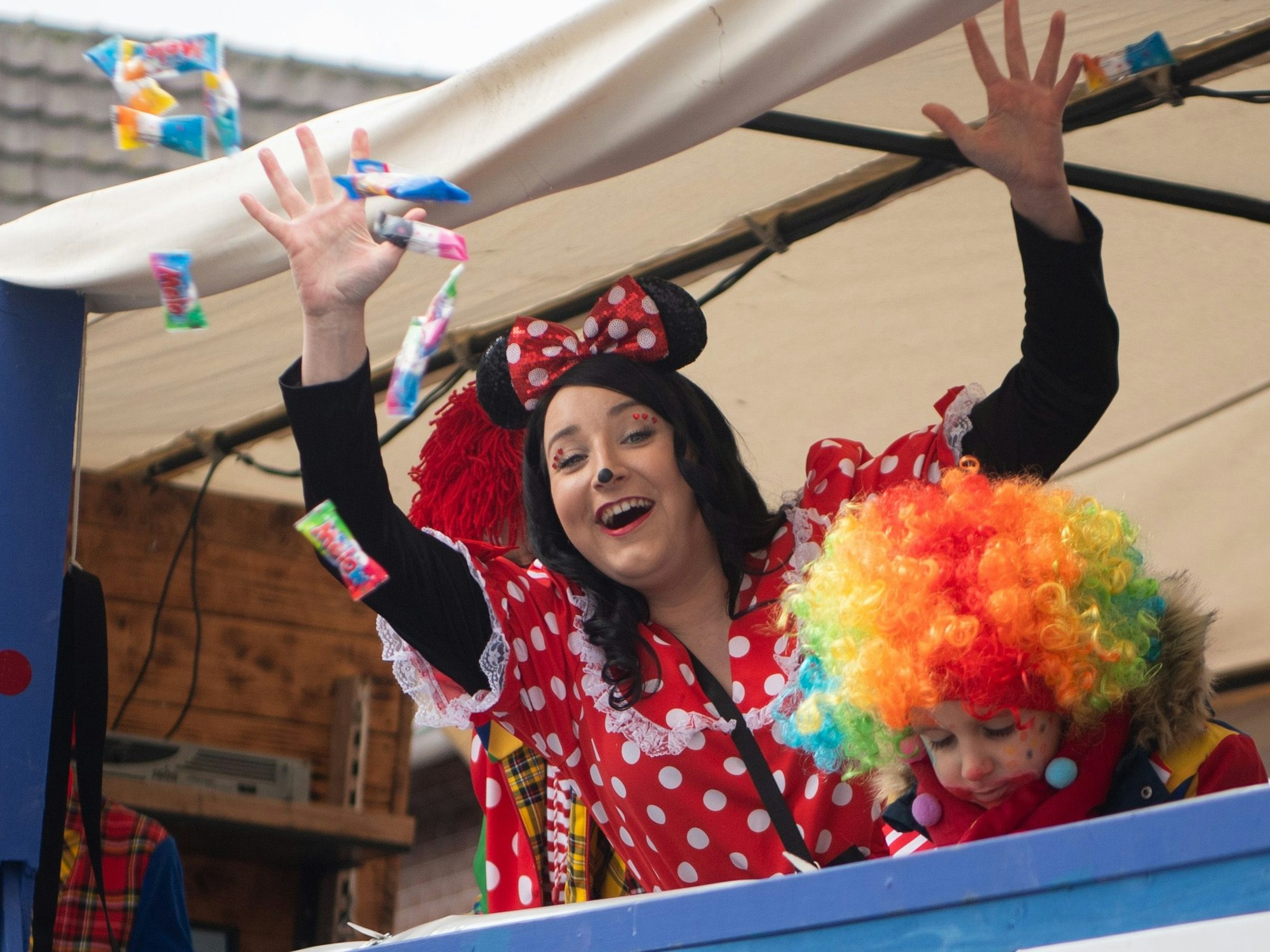 Kamelle und Kuchem alaaf: Eine als Minnie Maus verkleidete Karnevalistin wirft Süßigkeiten von einem Wagen.