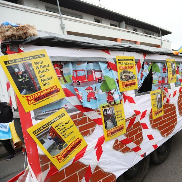 Ein Karnevalswagen mit Fotos und Schildern, auf denen die Feuerwehr die misslichen Zustände im Gerätehaus deutlich macht.