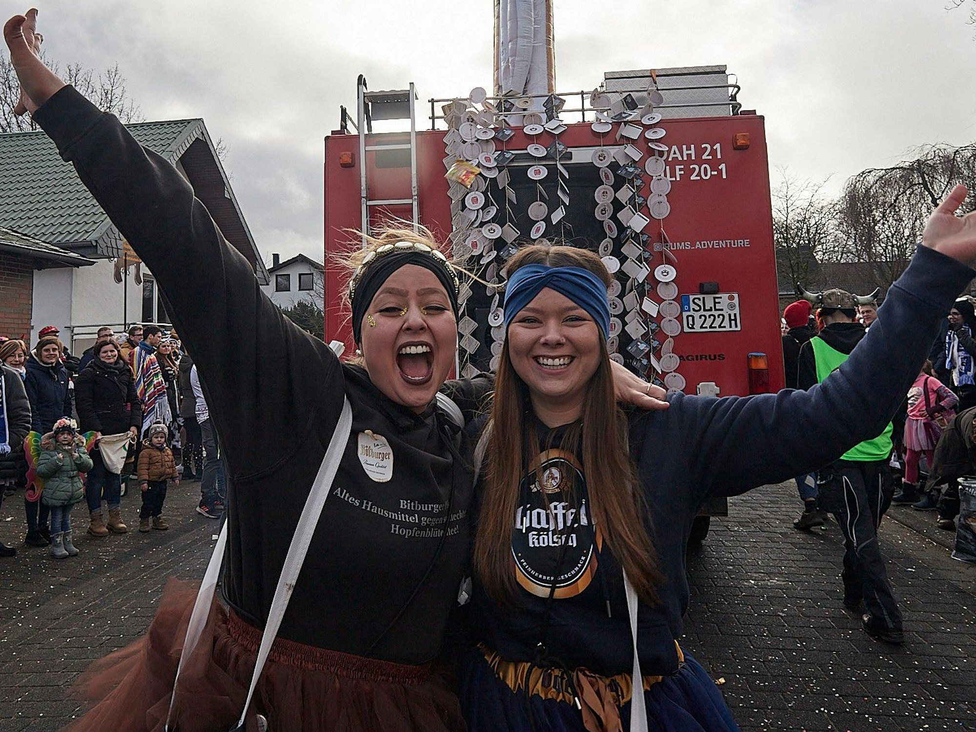 Im Zug und am Straßenrand herrschte in Udenbreth 1a-Feierstimmung. Zwei junge Karnevalistinnen halten sich im Arm und lachen.