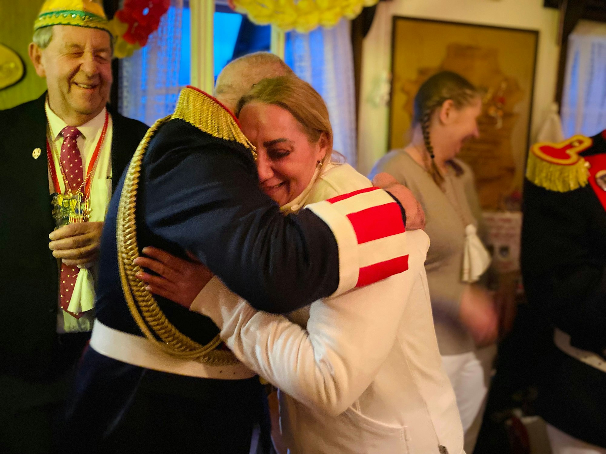 Blankenheimer Karnevalisten in dunklen Jacken stehen bei Prinzessin Dilek, die als Obergeist in Weiß gekleidet ist. Ein Mann umarmt sie.