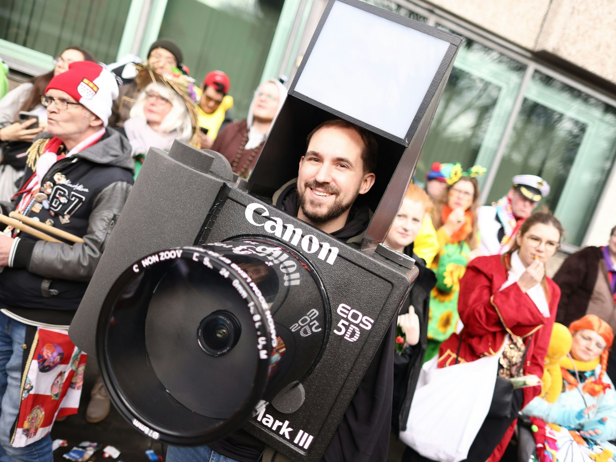 Ein Karnevalist ist als Fotokamera verkleidet.