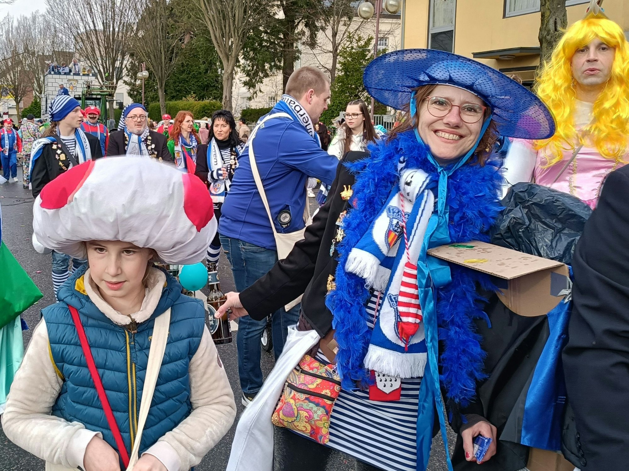Eine Frau mit einer blauen Federboa und einem blauen Hut.
