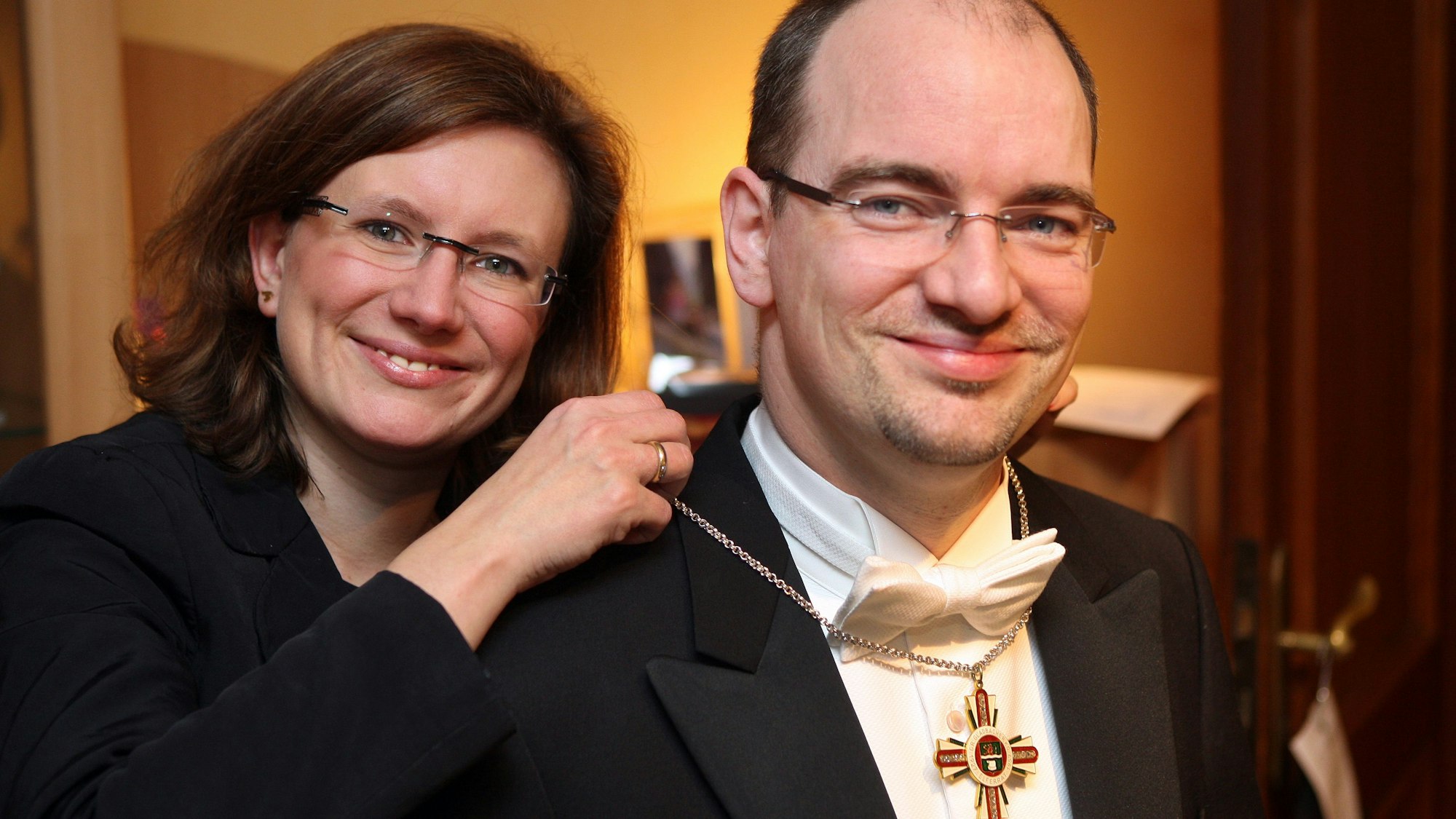 Melanie Pfister legt ihrem Mann Alexander das Halskreuz der Großen Gladbacher KG an.