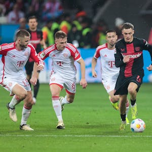 Bayerns Eric Dier, Joshua Kimmich und Raphael Guerreiro verfolgen Levekusens Florian Wirtz.