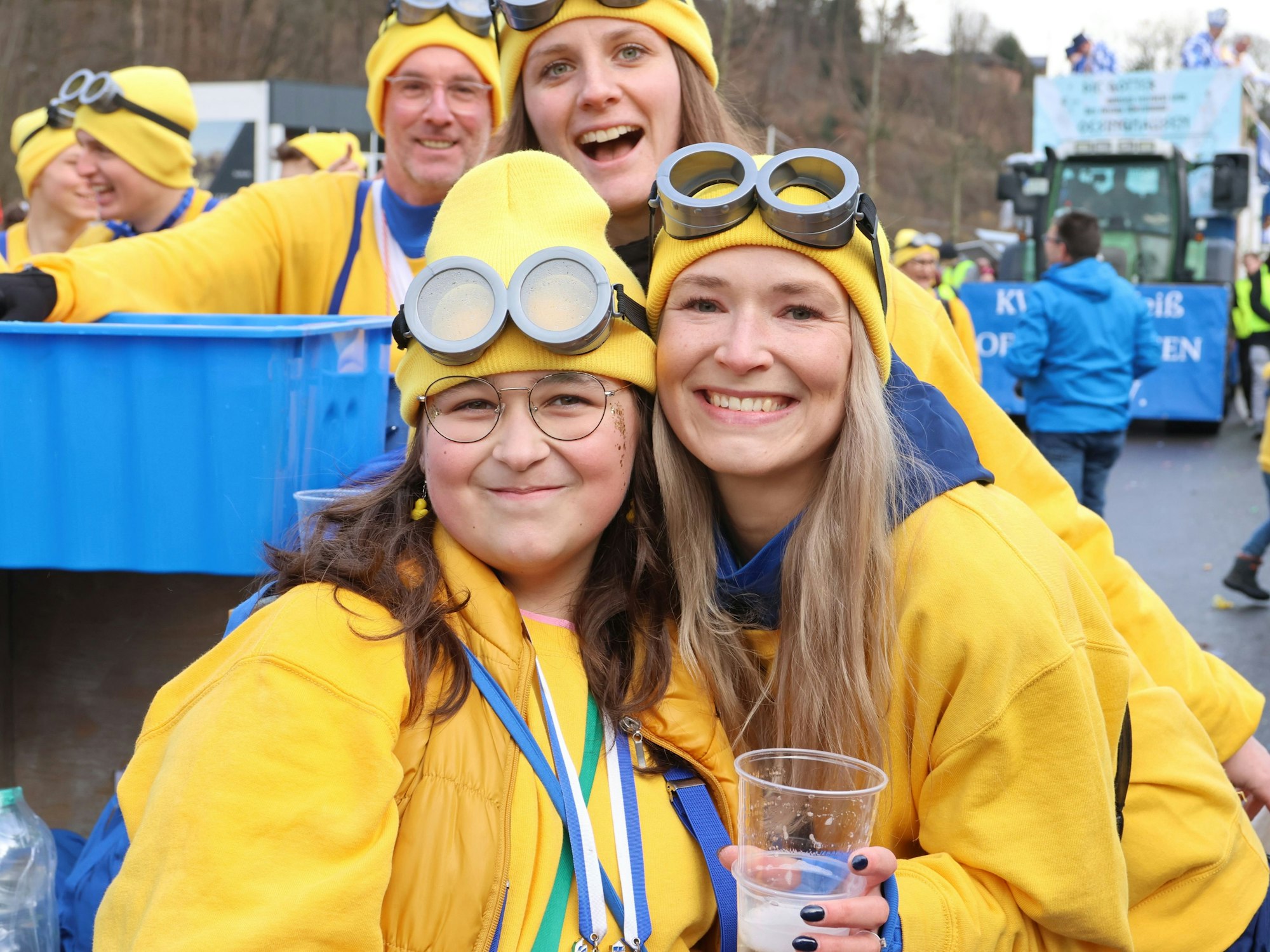 Zwei junge Frauen mit dicken Brillen und gelben Mützen.