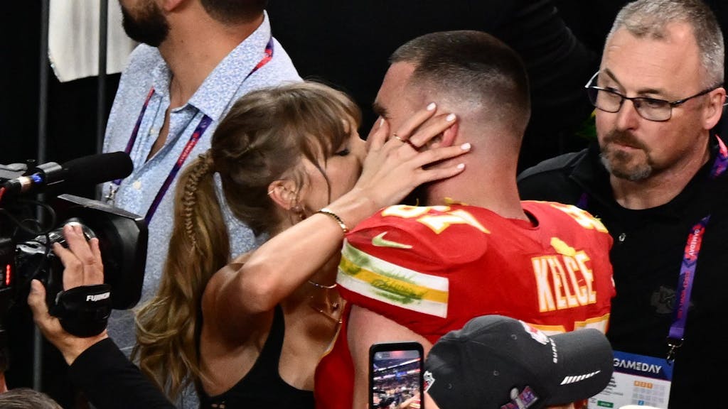 Taylor Swift küsst Kansas City Chiefs Tight End Travis Kelce nach dem Sieg. Swift ist zu einer wichtigen Marketinggröße in der NFL geworden, das Paar bewegt Massen. Könnte Swift auch die US-Wahl beeinflussen?