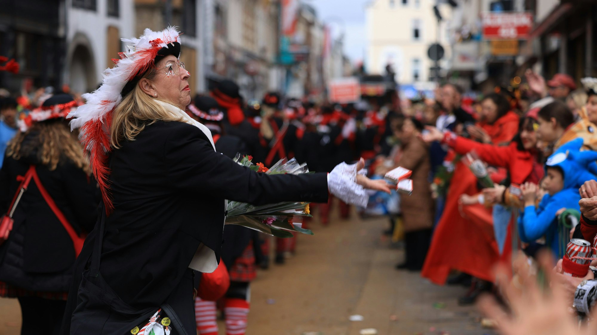 Eine Karnevalistin verteilt Süßigkeiten während des Rosenmontagsumzugs.