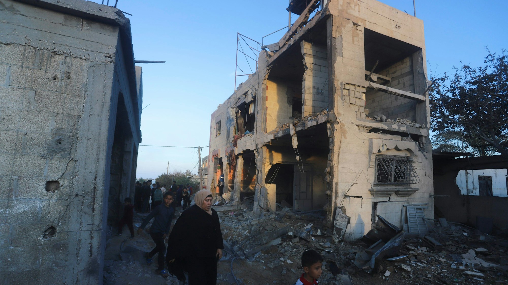 Palästinenser gehen an einem Wohnhaus vorbei, das bei einem israelischen Luftangriff zerstört wurde.